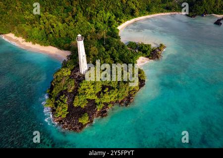 Vista aerea di un faro rustico, spiaggia sabbiosa sull'isola tropicale di Labengki con vegetazione lussureggiante, al largo della costa di Sulawesi, Indonesia, Asia Foto Stock