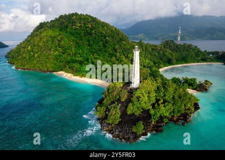Veduta aerea di uno splendido faro, spiaggia sabbiosa e barche da pesca e isola tropicale di Labengki con vegetazione lussureggiante, Sulawesi in Indonesia Foto Stock