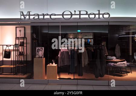 Marco o Polo Fashion Store am Flughafen München. DAS Modelabel Marc o Polo wurde 1967 von den Schweden Rolf Lind, Goete Huss und dem US-Amerikaner Jerry o Sheets a Stoccolma gegründet. Kern der Markenidentität ist die Verwendung natürlicher Materialien. Die deutsche Tochtergesellschaft Marc o Polo Deutschland wurde im Jahr 1968 durch Werner Böck mit Sitz in Stephanskirchen im Landkreis Rosenheim gegründet. Im Jahr 1987 übernahm Böck 40 Prozent der Anteile der schwedischen Muttergesellschaft. IM Zuge der Übernahme von Weiteren 40 Prozent im Jahr 1997 wurde die Marc o Polo International GmbH in Foto Stock