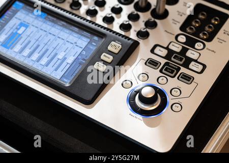 Vista ravvicinata di una moderna console di missaggio audio dotata di varie manopole, pulsanti e display digitale. La console è progettata per i professionisti Foto Stock