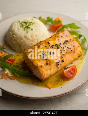 Salmone al forno con salsa all'arancia. Tavolo con vista dall'alto e decorazioni. Foto Stock