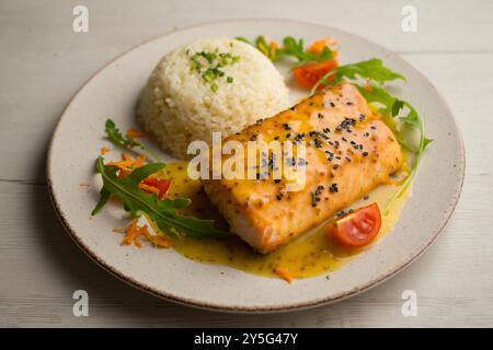 Salmone al forno con salsa all'arancia. Tavolo con vista dall'alto e decorazioni. Foto Stock