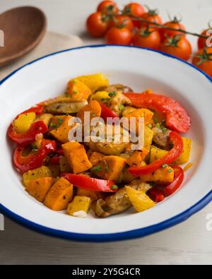 Pollo fritto in padella con patate dolci, ananas e pepe rosso. Tavolo con vista dall'alto e decorazioni. Foto Stock