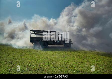 Nijmegen, Gheldria, Paesi Bassi. 19 settembre 2024. Le macchine per il fumo forniscono copertura sulle rive del Waal durante una prova di ''l'attraversamento del Waal''. Questi reenattori praticano la rievocazione dell'"attraversamento del Waal". La pratica si svolse vicino al fiume Waal in un'area di traboccamento chiamata Nevengeul. Questo è anche il luogo in cui si trova il monumento sulla diga. 80 anni fa, 260 soldati della 82a Divisione aviotrasportata attraversarono il Waal in 26 barche di tela per attaccare il ponte Waal da sud e da est contemporaneamente. La metà dei 260 soldati rimasero feriti e 48 furono uccisi in questa azione. Foto Stock