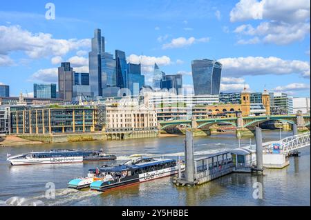 Londra, Regno Unito. Barche turistiche Uber al molo di Bankside di fronte allo skyline della City of London Foto Stock