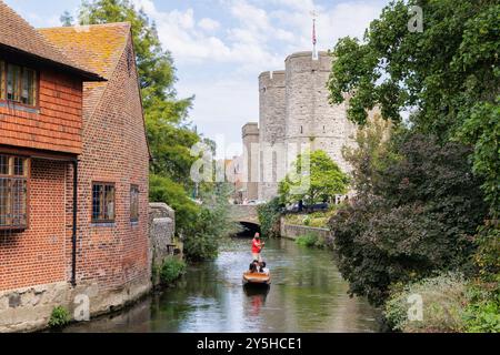 Canterbury, Kent, Regno Unito - settembre 2024: Un uomo che indossa una maglietta rossa punta una barca contenente tre persone lungo il fiume Great Stour a Westgate Gardens. Foto Stock