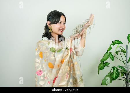 Bella donna asiatica a Kurtha per Diwali che dà espressioni e gesti con luci natalizie a LED Foto Stock