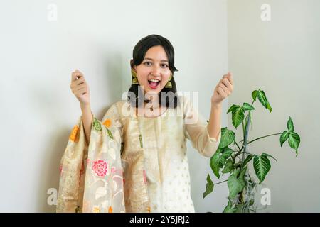 Bella donna asiatica a Kurtha per Diwali che dà espressioni e gesti con luci natalizie a LED Foto Stock