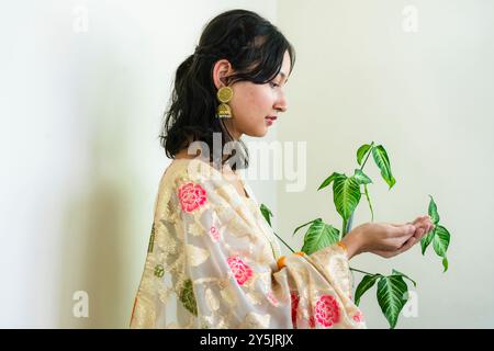 Bella donna asiatica a Kurtha per Diwali che dà espressioni e gesti con luci natalizie a LED Foto Stock