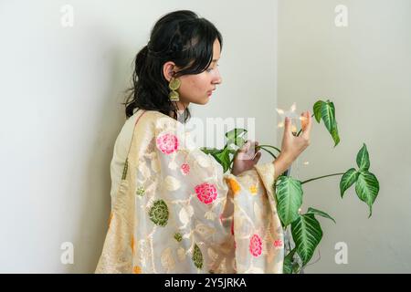 Bella donna asiatica a Kurtha per Diwali che dà espressioni e gesti con luci natalizie a LED Foto Stock