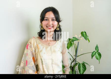 Bella donna asiatica a Kurtha per Diwali che dà espressioni e gesti con luci natalizie a LED Foto Stock