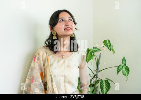 Bella donna asiatica a Kurtha per Diwali che dà espressioni e gesti con luci natalizie a LED Foto Stock