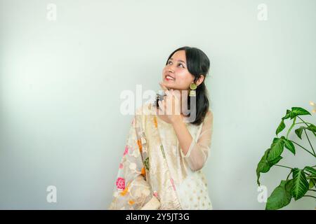 Bella donna asiatica a Kurtha per Diwali che dà espressioni e gesti con luci natalizie a LED Foto Stock