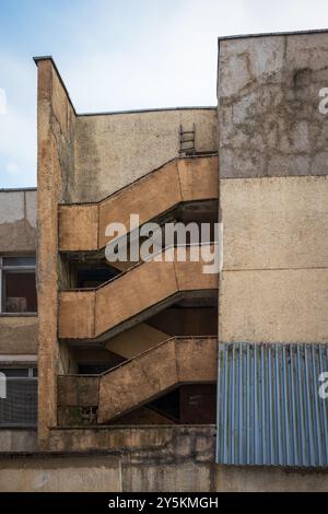 Pareti in cemento e resti di scale in un vecchio edificio industriale abbandonato. Foto Stock