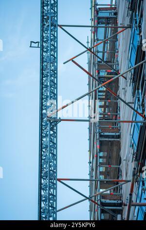 Edificio di appartamenti avvolti in rete di teli per ponteggi durante l'isolamento in inghilterra regno unito. Foto Stock