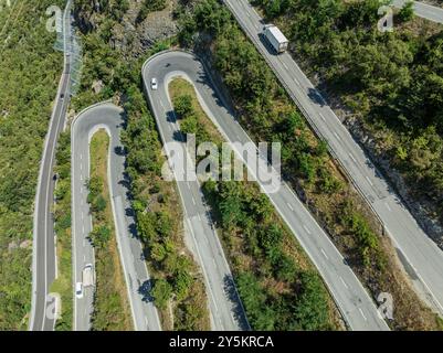 Strada del passo di montagna con tornanti multipli, conduttura d'acqua, vista aerea, colpo di droni. Vallese, Svizzera Foto Stock