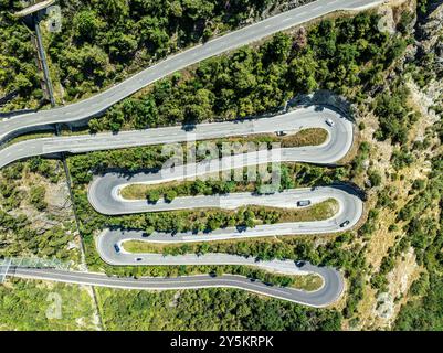 Strada del passo di montagna con tornanti multipli, conduttura d'acqua, vista aerea, colpo di droni. Vallese, Svizzera Foto Stock