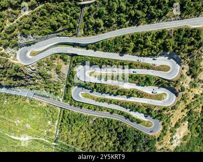 Strada del passo di montagna con tornanti multipli, conduttura d'acqua, vista aerea, colpo di droni. Vallese, Svizzera Foto Stock