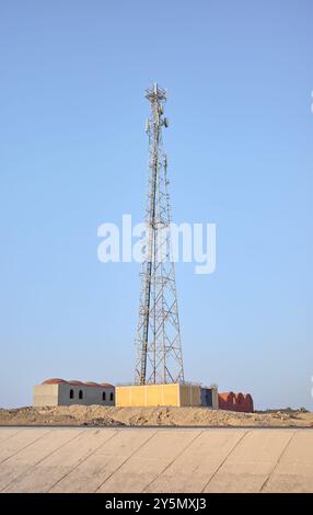 Una foto di una torre di telecomunicazioni contro un cielo blu. Foto Stock