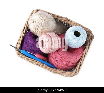 Molti filati colorati e ganci a uncinetto nel cestello in vimini isolato sul bianco, vista dall'alto Foto Stock