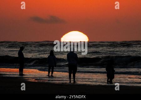 Isola di Palms, Stati Uniti. 22 settembre 2024. Una famiglia sagomata dal sole si ferma per vedere l'alba mentre sbircia sull'orizzonte dell'Oceano Atlantico, 22 settembre 2024 a Isle of Palms, Carolina del Sud. Crediti: Richard Ellis/Richard Ellis/Alamy Live News Foto Stock