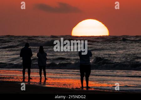 Isola di Palms, Stati Uniti. 22 settembre 2024. Una famiglia sagomata dal sole si ferma per vedere l'alba mentre sbircia sull'orizzonte dell'Oceano Atlantico, 22 settembre 2024 a Isle of Palms, Carolina del Sud. Crediti: Richard Ellis/Richard Ellis/Alamy Live News Foto Stock