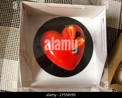 Torta rossa con fragole a forma di cuore. Dolci e regali per San Valentino Foto Stock