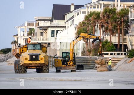 Isola di Palms, Stati Uniti. 12 settembre 2024. I lavoratori utilizzano macchinari pesanti per posizionare sacchi di sabbia giganti davanti alle proprietà sul lungomare per impedire che l'erosione delle maree minasse le fondamenta sulla spiaggia di Wild Dunes, 12 settembre 2024, a Isle of Palms, South Carolina. Il cambiamento climatico sta causando maree sempre più forti, che rimuovono centinaia di metri dalle spiagge lungo la regione del basso paese. Crediti: Richard Ellis/Richard Ellis/Alamy Live News Foto Stock