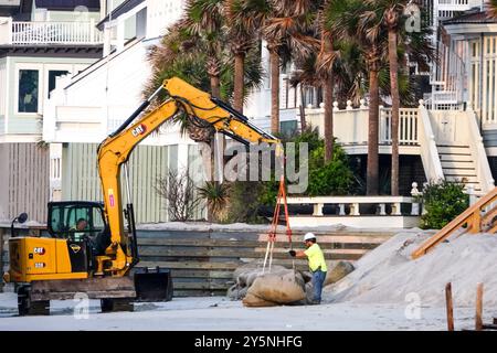 Isola di Palms, Stati Uniti. 12 settembre 2024. I lavoratori utilizzano macchinari pesanti per posizionare sacchi di sabbia giganti davanti alle proprietà sul lungomare per impedire che l'erosione delle maree minasse le fondamenta sulla spiaggia di Wild Dunes, 12 settembre 2024, a Isle of Palms, South Carolina. Il cambiamento climatico sta causando maree sempre più forti, che rimuovono centinaia di metri dalle spiagge lungo la regione del basso paese. Crediti: Richard Ellis/Richard Ellis/Alamy Live News Foto Stock