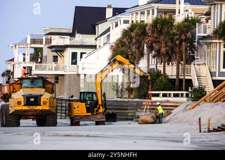 Isola di Palms, Stati Uniti. 12 settembre 2024. I lavoratori utilizzano macchinari pesanti per posizionare sacchi di sabbia giganti davanti alle proprietà sul lungomare per impedire che l'erosione delle maree minasse le fondamenta sulla spiaggia di Wild Dunes, 12 settembre 2024, a Isle of Palms, South Carolina. Il cambiamento climatico sta causando maree sempre più forti, che rimuovono centinaia di metri dalle spiagge lungo la regione del basso paese. Crediti: Richard Ellis/Richard Ellis/Alamy Live News Foto Stock