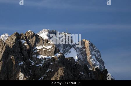 Garmisch-Partenkirchen, Bayern, Deutschland 22. Settembre 2024: Ein Spätsommertag bei Garmisch-Partenkirchen. Hier der Blick auf die Zugspitze mit der Bergstation der Seilbahn, Fels, Berg, Gipfel, Bergsteigen, Alpin, Schnee, Wahrzeichen *** Garmisch Partenkirchen, Baviera, Germania 22 settembre 2024 Una tarda giornata estiva nei pressi di Garmisch Partenkirchen qui la vista dello Zugspitze con la stazione a monte della funivia, roccia, montagna, vetta, alpinismo, alpino, neve, punto di riferimento Foto Stock