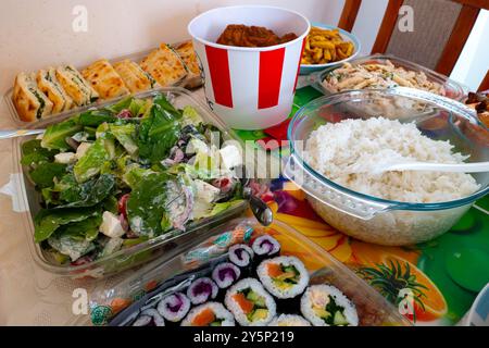 Una selezione di piatti, un buffet per una festa in famiglia che include una vasca di pollo KFC su un tavolo Foto Stock