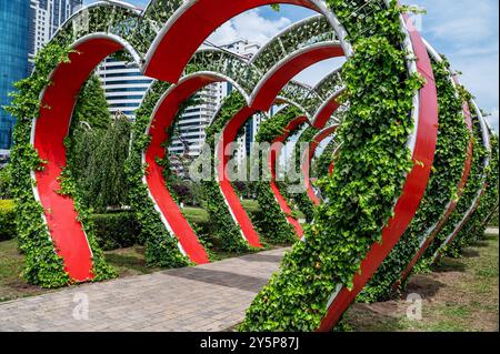 Vista sulla città del parco dei fiori. Arco floreale con giardini di piante di petunia. Un numero enorme di vasi di fiori su supporti metallici. Foto Stock