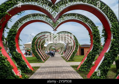 Vista sulla città del parco dei fiori. Arco floreale con giardini di piante di petunia. Un numero enorme di vasi di fiori su supporti metallici. Foto Stock