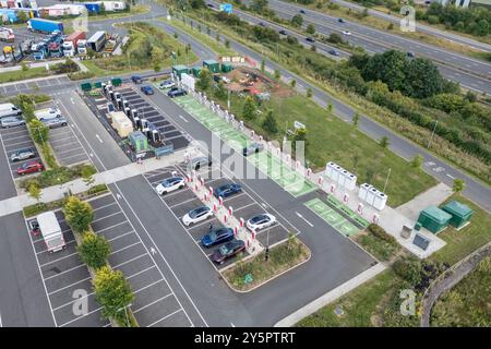 Vista aerea della stazione di ricarica per veicoli elettrici presso la stazione di servizio Moto Rugby (svincolo 1, autostrada M6), svincolo 1, Rugby, Foto Stock