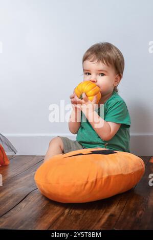 Ritratto di un bambino carino con la zucca nelle decorazioni di Halloween Foto Stock