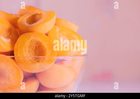 Metà di albicocche in un recipiente di vetro, primo piano. Albicocca snocciolata per preparare la marmellata o il ripieno, enfasi sui dettagli, primo piano, alta risoluzione Foto Stock