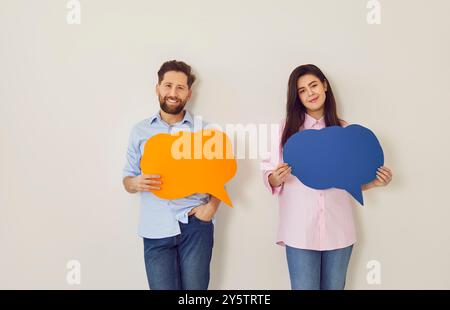 Uomo e donna hanno grandi bolle colorate che simboleggiano la comunicazione e lo scambio di idee. Foto Stock