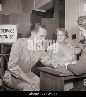 America degli anni '1940 Un soldato che chiede aiuto per sua madre all'ufficio di servizio della Croce Rossa. Questo servizio si occupa dei problemi personali dei militari, funge da collegamento tra loro e le loro famiglie a casa e spesso li aiuta con prestiti o sovvenzioni di denaro. STATI UNITI. Washington, D.C. giugno 1942 Foto Stock