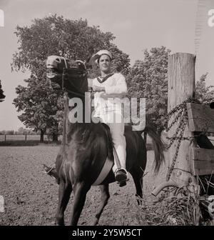 America degli anni '1940 Marinaio belga che cavalcava in una fattoria dove gli eroi erano intrattenuti durante la settimana delle Nazioni Unite. Oswego, New York. Giugno 1943 (di M. Collins, fotografo) Foto Stock