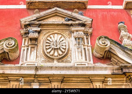 Lisbona, Portogallo - 19 settembre 2024: Piccioni arroccati su una decorazione in pietra medievale sulla facciata di un edificio. Foto Stock
