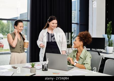 Tre donne professionali si impegnano in una discussione stimolante mentre lavorano in ufficio. Foto Stock