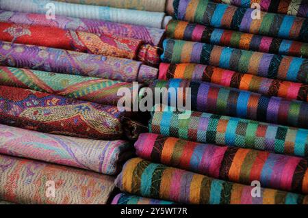 Dettaglio ravvicinato di pile di sciarpe di pashmina in cashmere colorate e fantasia vendute in un mercato mediorientale. . Foto Stock