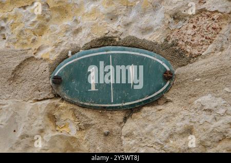 Una strada di metallo numero uno con la lettera araba "alif" che ha il valore di "uno" su un muro di pietra fuori da una casa nel quartiere musulmano della vecchia C. Foto Stock