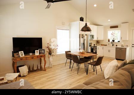 Moderno soggiorno collegato perfettamente ad una cucina con mobili contemporanei e pavimento in legno in un open space, Florida, USA Foto Stock