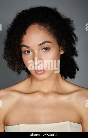 Una donna elegante posa graziosamente in un'atmosfera da studio tranquilla ed elegante. Foto Stock