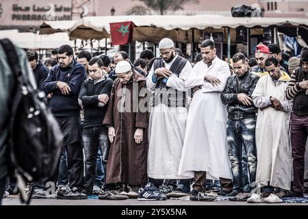 Musulmani che pregano di fronte a una moschea, Piazza Jamaa el Fna, Marrakech, Marocco, Nord Africa, continente africano Foto Stock