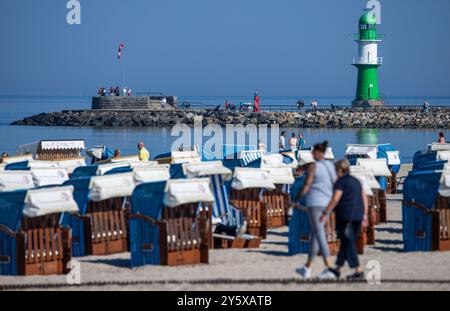 Rostock, Germania. 23 settembre 2024. I vacanzieri e i visitatori giornalieri approfittano del clima soleggiato sulla spiaggia del Mar Baltico di Warnemünde per una passeggiata lungo la costa. Soleggiato, quasi ventoso e con temperature miti, il clima autunnale sta attualmente mostrando il suo lato amichevole nella Germania settentrionale. Crediti: Jens Büttner/dpa/Alamy Live News Foto Stock