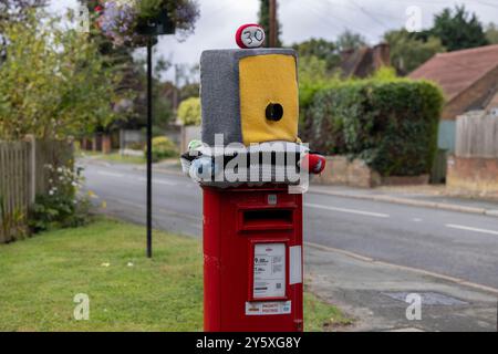 Autovelox lavorato a maglia con coperchio della scatola postale, decorazioni all'uncinetto destinate a scoraggiare i conducenti dall'andare in velocità lungo una strada residenziale nell'Hampshire, Regno Unito Foto Stock