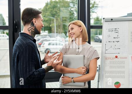 Due giovani professionisti condividono idee e sorrisi in un ambiente luminoso. Foto Stock